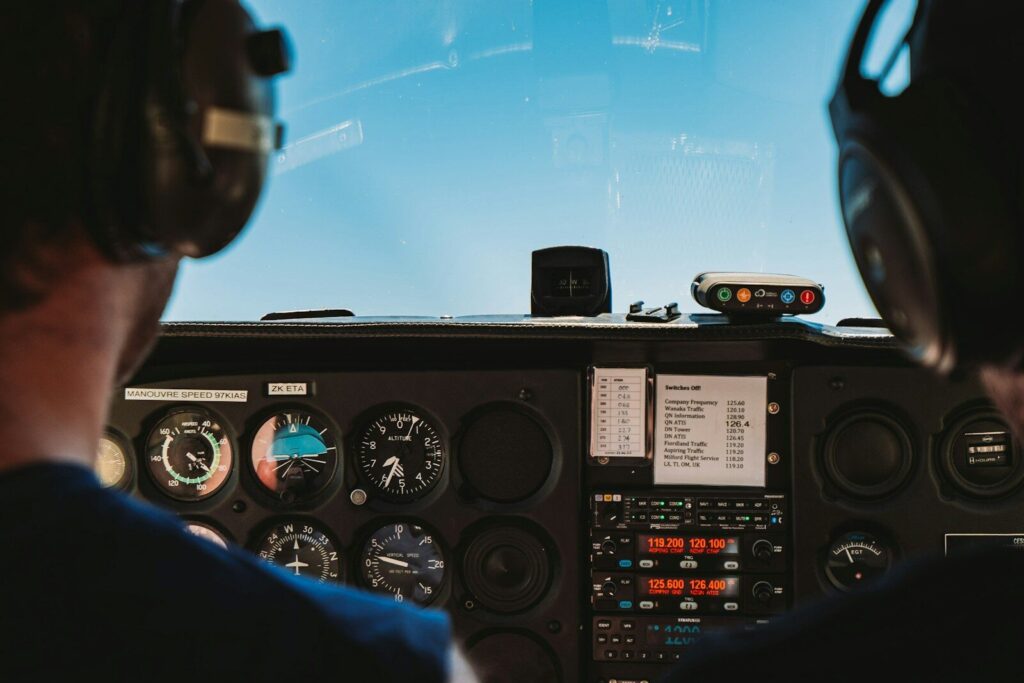 Two UK pilots wearing headsets in a light-aircraft cockpit