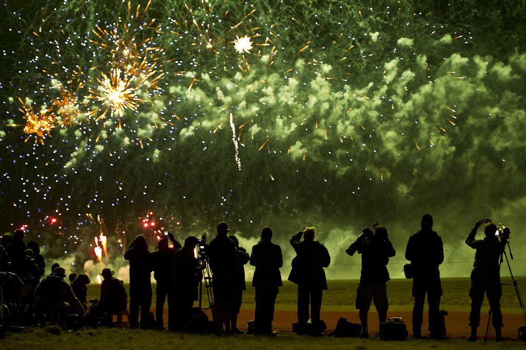 Fireworks Night at IWM Duxford (with FIDO recreation) – image Spectators and photographers silhouetted against fireworks on an airfield (Avalon Airshow 2013, US Pacific Air Forces photo)